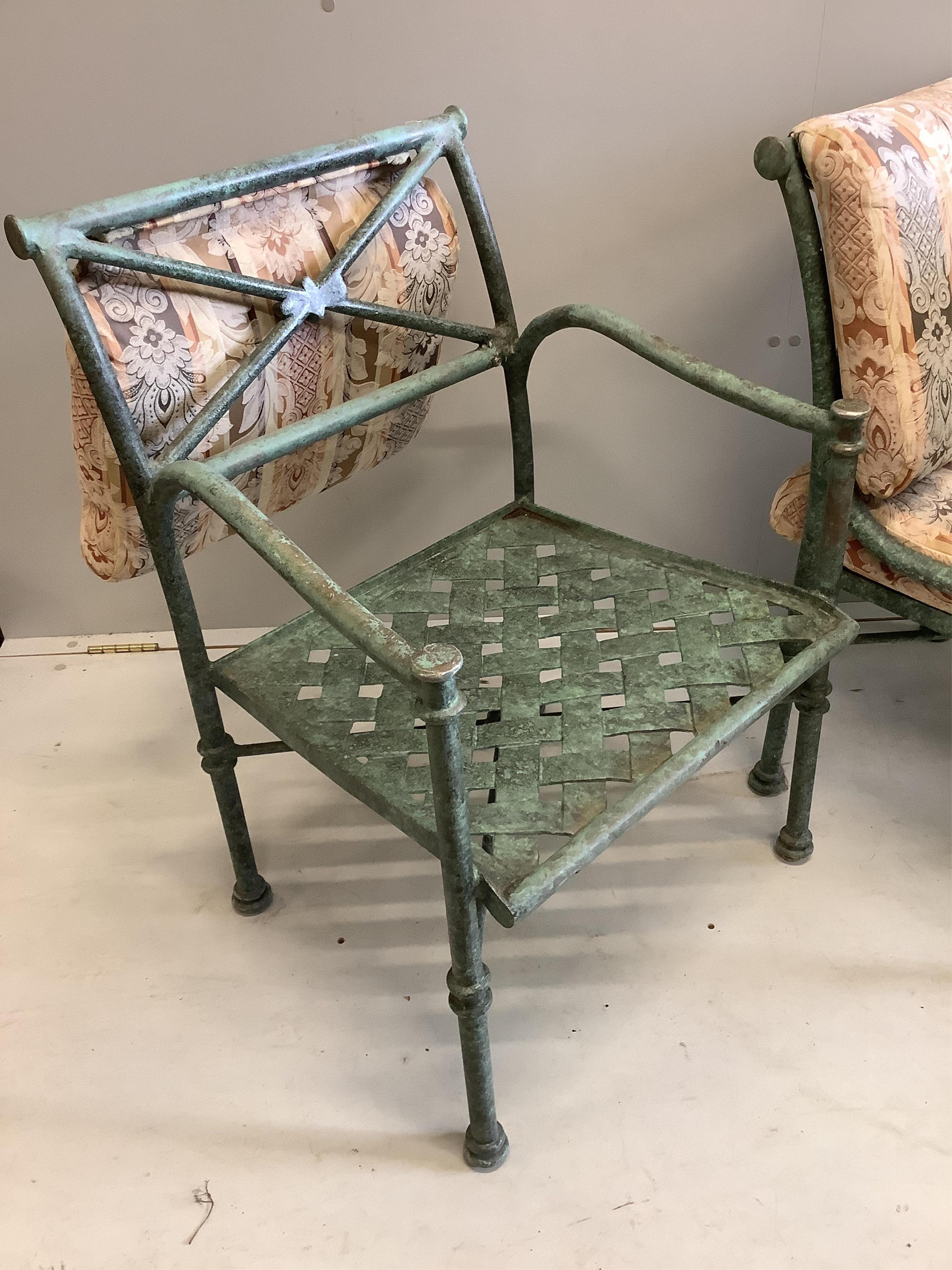 A green patinated iron palm tree design glass topped conservatory table, diameter 106cm, height 74cm and four matching armchairs with cushion seats and backs. Condition - fair to good